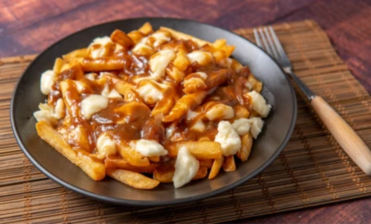 Une assiette de poutine : des frites avec du fromage et de la sauce brune
